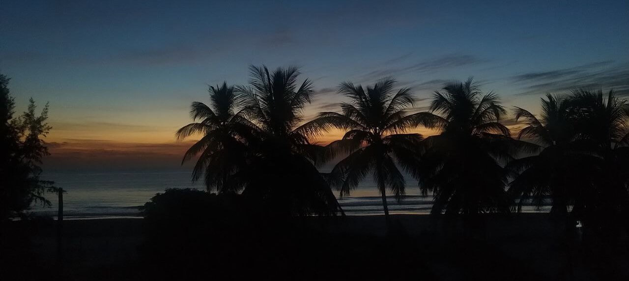 L'océan Atlantique à Cap-Skirring avec ses vagues douces et le ciel aux teintes pastel du crépuscule ou de l'aube, offrant une ambiance sereine et des couleurs apaisantes près du Campement Buhanor