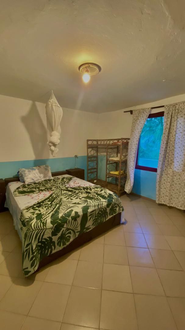 Intérieur d'une Chambre confortable du Campement Buhanor à Cap-Skirring avec vue sur l'océan, lit double et lumière naturelle, idéale pour vos séjours en Casamance