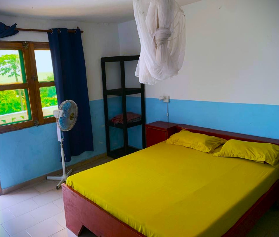 Chambre spacieuse et lumineuse avec vue mer du Campement Buhanor à Cap-Skirring, lit confortable avec moustiquaire, idéale pour un séjour premium.