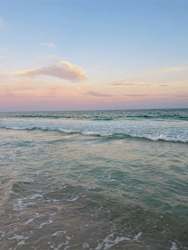 Calmes vagues de l'océan Atlantique à Cap-Skirring sous un ciel serein aux teintes douces, une atmosphère relaxante typique des paysages près du Campement Buhanor.
