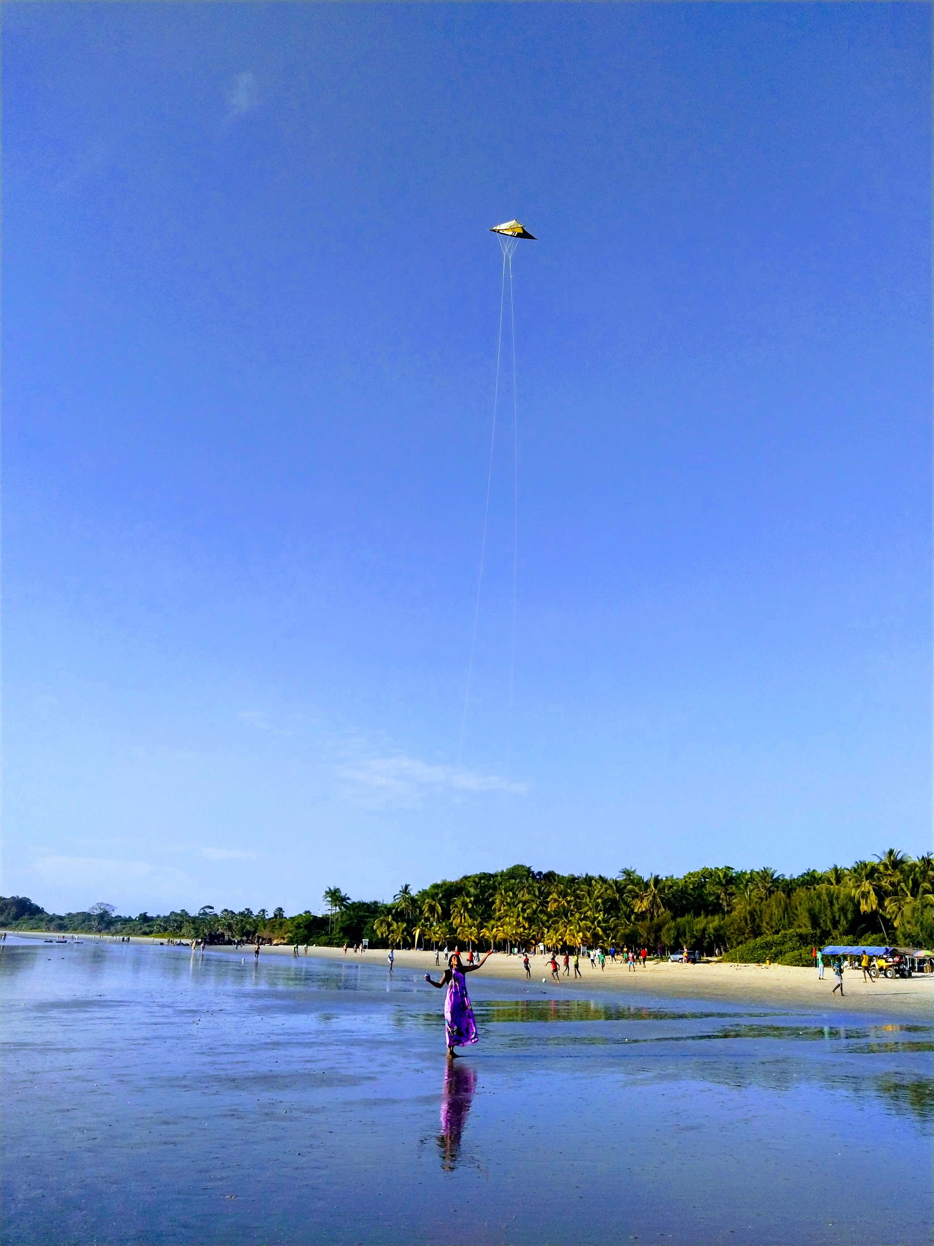 Activité de cerf-volant sur la plage ensoleillée de Cap-Skirring, une animation joyeuse au bord de l'océan près du Campement Buhanor en Casamance.