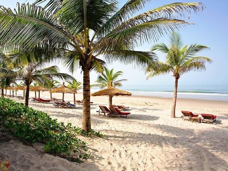 Plage idyllique de Cap-Skirring avec palmiers, parasols et transats, invitante à la détente au soleil près du Campement Buhanor.